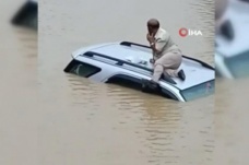 Hindistan’da selde mahsur kalan sürücü aracının üzerinde kurtarılmayı bekledi