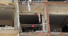 Saldırıda harap olan binaya Türk bayrakları astı